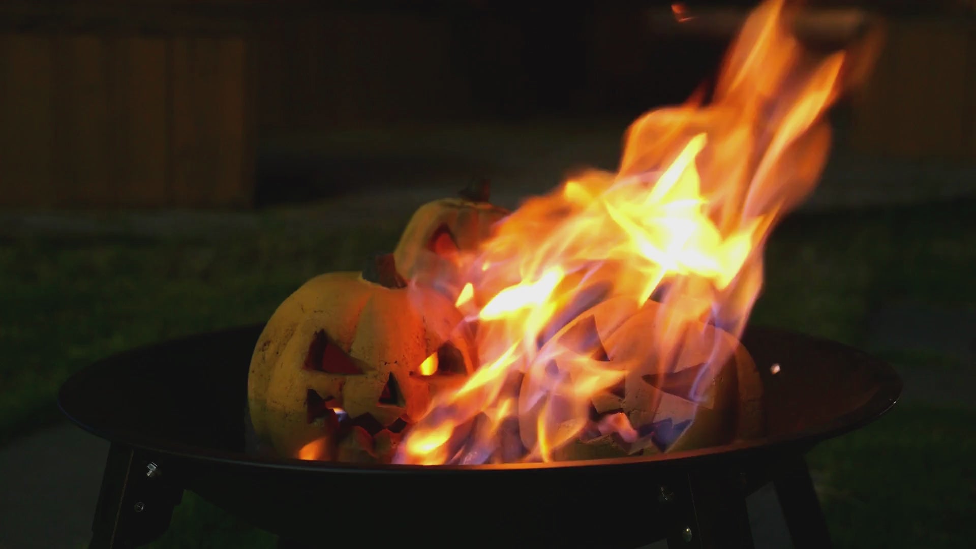 Load video: there is taller shorter pumpkin logs in outdoor fire pit